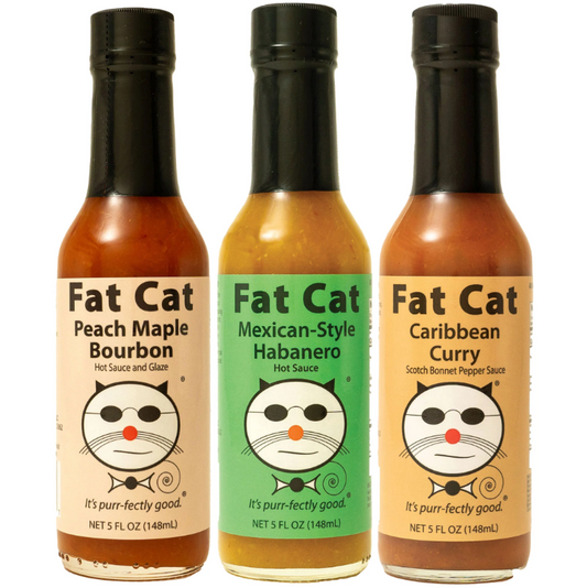 Three bottles of Fat Cat hot sauces with different flavors on a white background